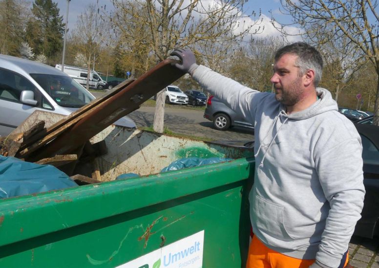 Kai Hauenstein vom Bauhof beim Abladen von Müll in den Container auf dem Parkplatz Johannisfeld.