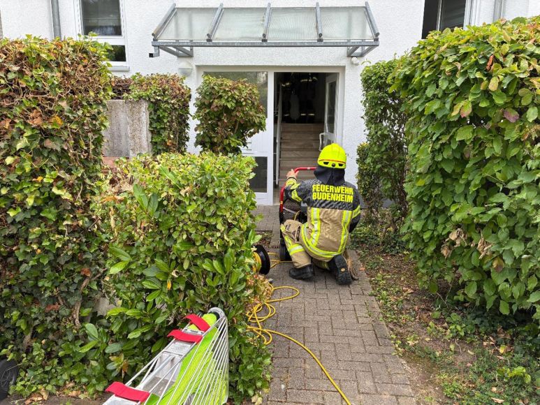 Ein Feuerwehrkamerad bereitet einen Lüfter vor, um eine verrauchte Wohnung zu belüften.