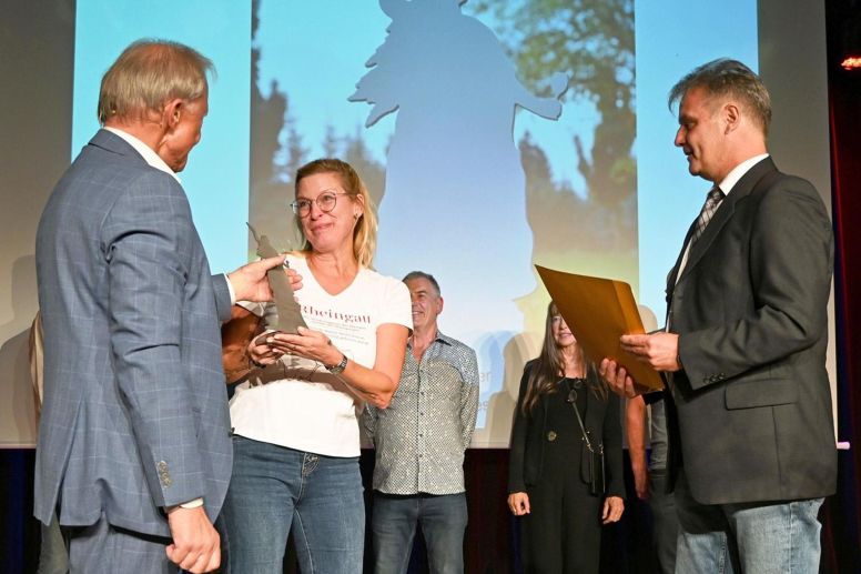 Maren Altpeter erhält von Wolfgang Junglas (links) die Trophäe und von Helmut Mertes den goldenen Umschlag.